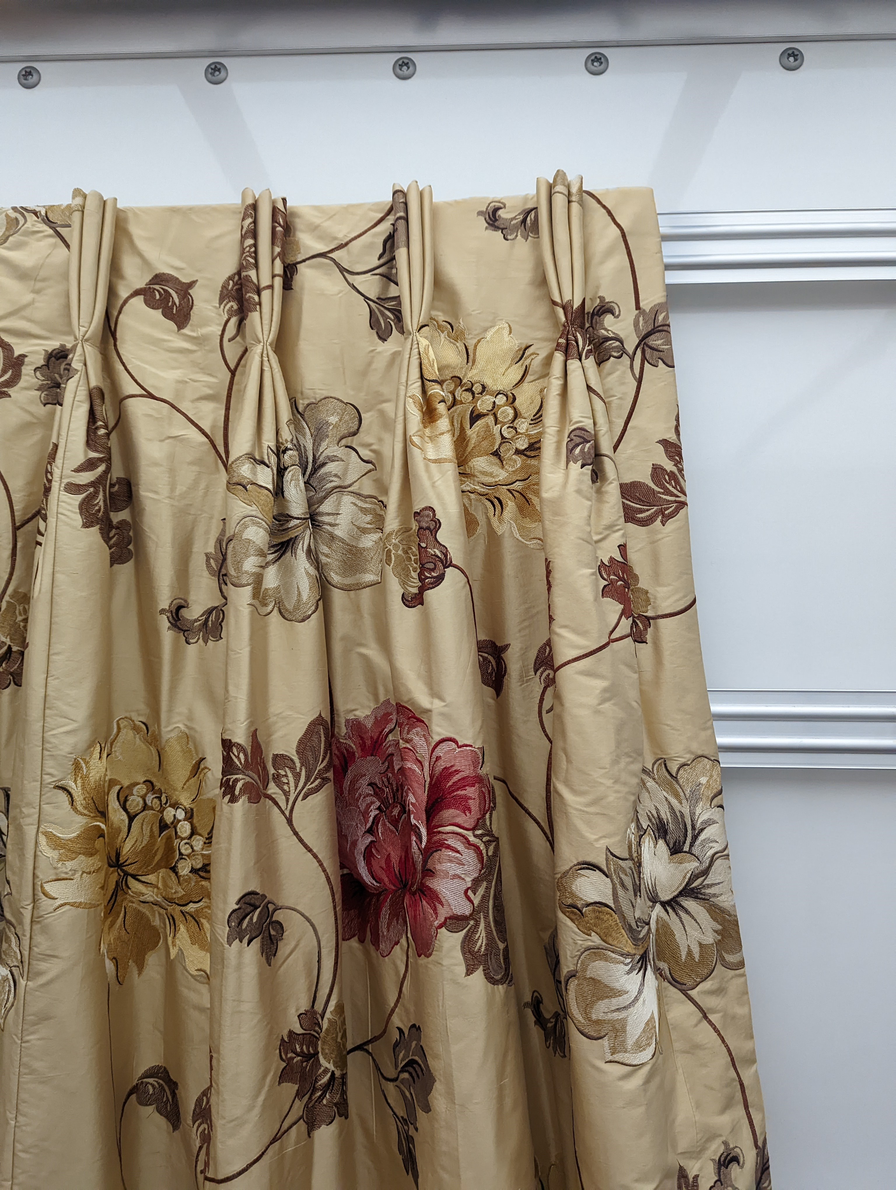 A pair of floral lined curtains. Approximate measurements: Width of top 110cm, Width of bottom 220cm Length 250cm